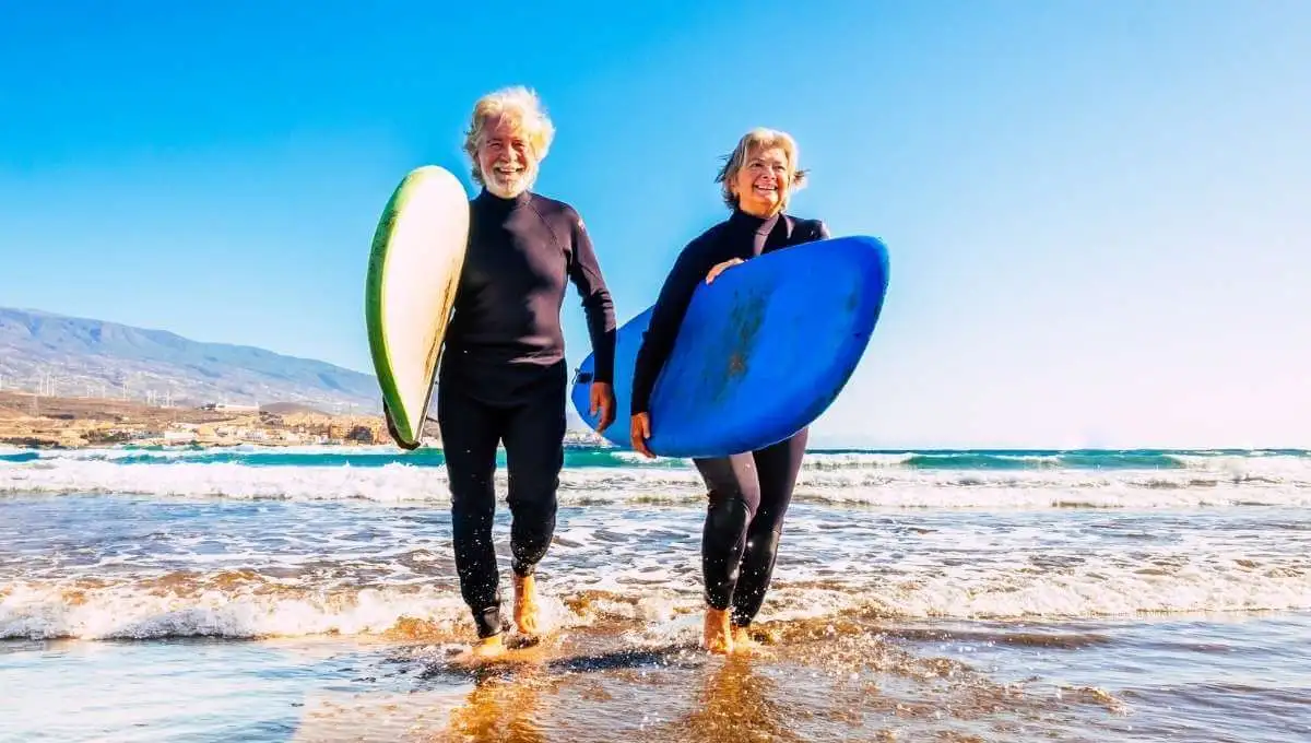 Elderly man and woman going beach surfing