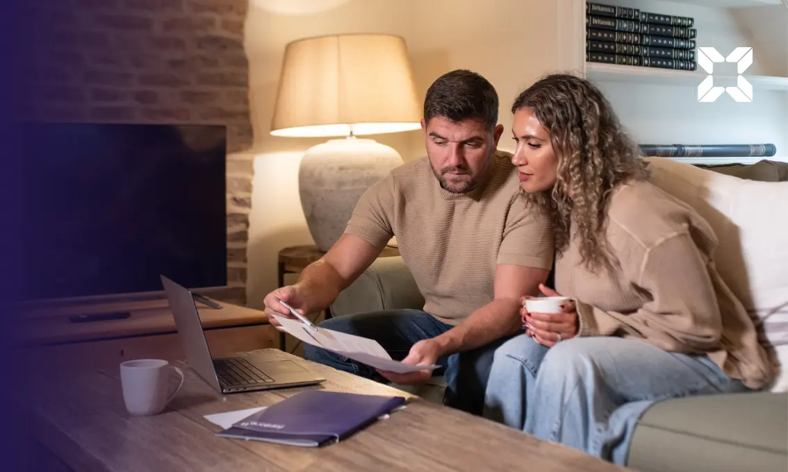 A couple sat at a coffee table looking at documentation.
