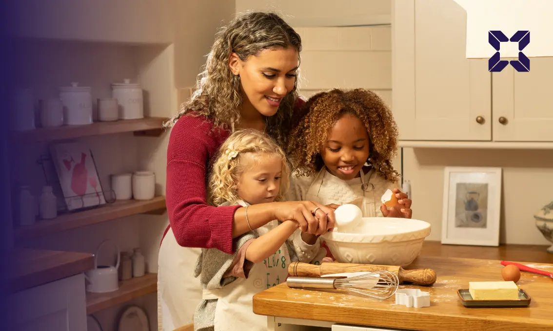 A mother and her two children baking in the kitchen. they are all smiling.