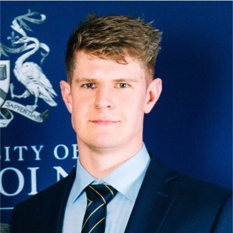 Image of Tom Yallop in blue suit with blue striped tie